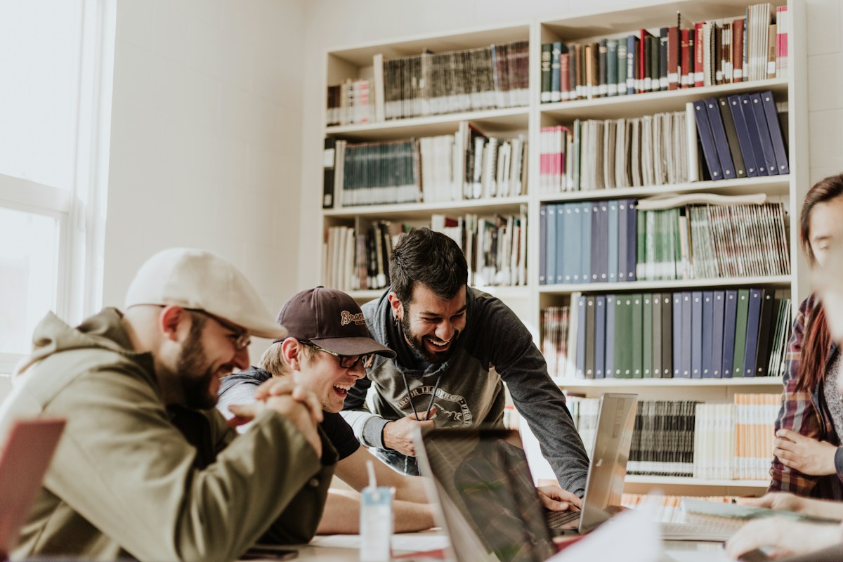 Students sharing ideas around a table in a university library